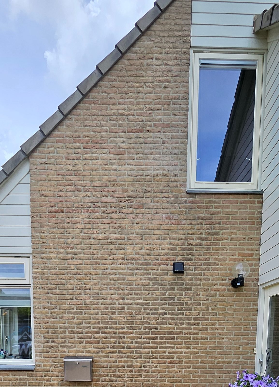 Na: dezelfde puntgevel, de baksteen is weer warm geelbruin