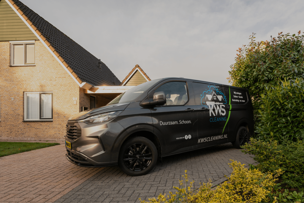 De bus van KWS Cleaning op een oprit voor een woning