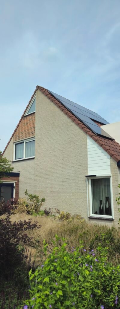Woning met puntgevel en zonnepanelen op het dak, met een tuin ervoor