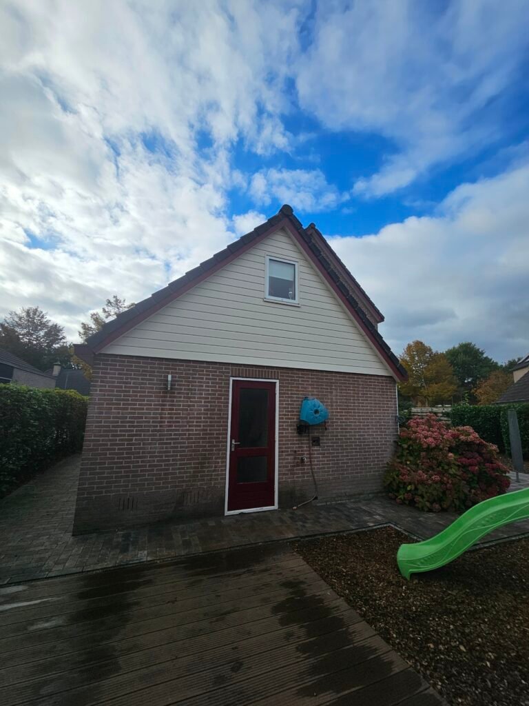 Woning met lichte beplating in de puntgevel na de reiniging