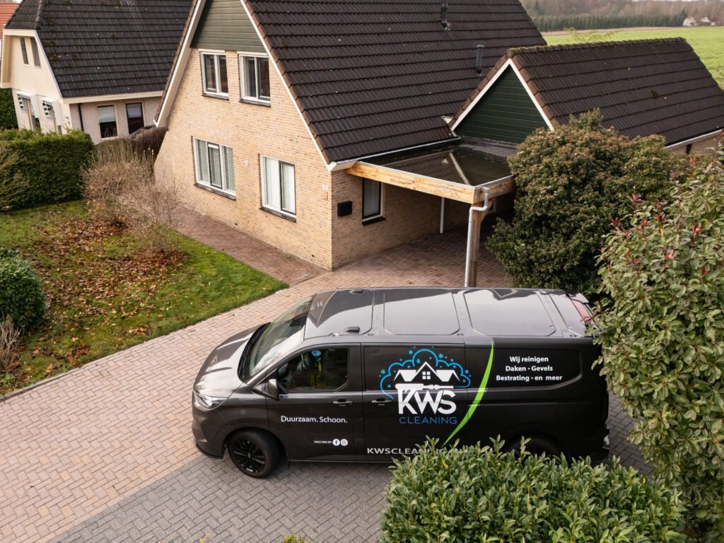 De KWS-bus op een klinkeroprit bij een woning met carport